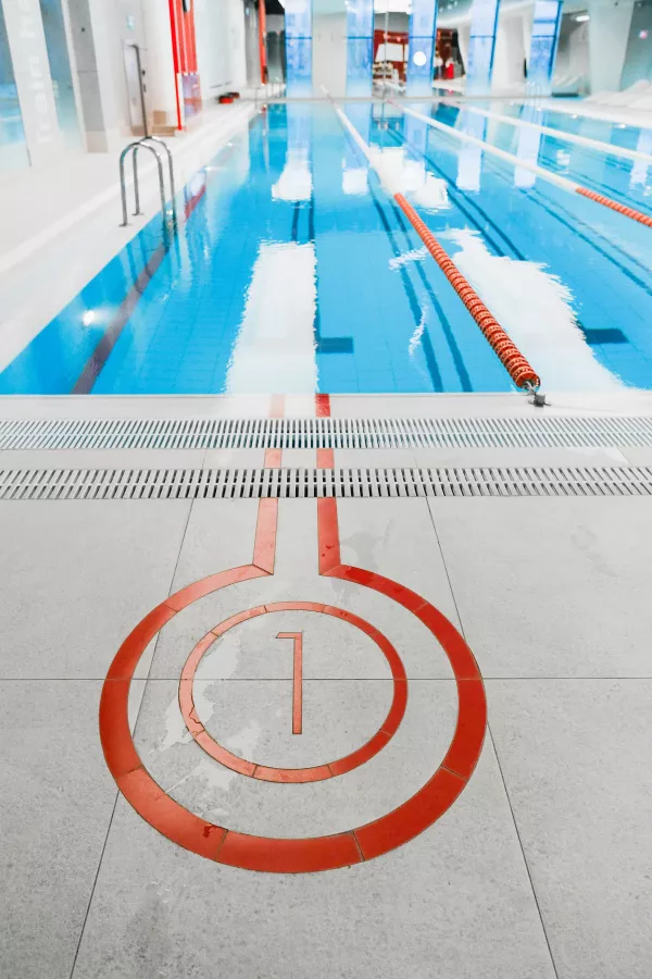 Extrémité du couloir numéro 1 d’une piscine intérieure avec les lignes de nage.