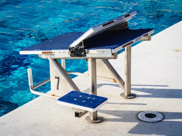 Bloc de départ numéro 7 au bord d’une piscine.
