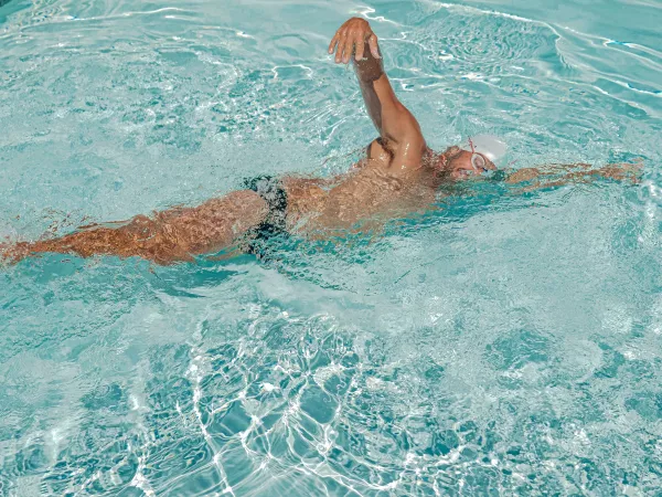 Nageur en crawl pendant un entraînement dans une piscine claire.