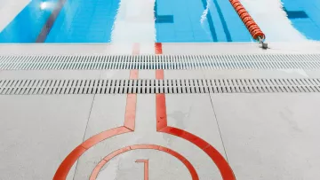 Extrémité du couloir numéro 1 d’une piscine intérieure avec les lignes de nage.