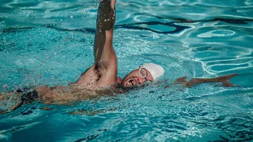 Nageur en crawl tournant la tête pour respirer pendant un entraînement.