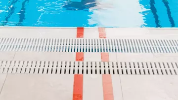 Nageur avançant dans le couloir 3 vers le mur d’une piscine intérieure.