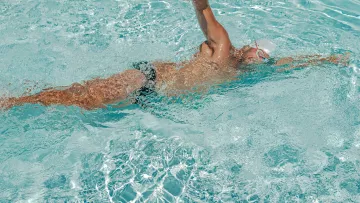Nageur en crawl pendant un entraînement dans une piscine claire.