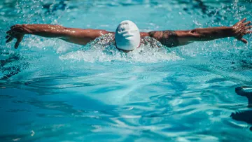 Nageur effectuant le papillon dans une piscine.